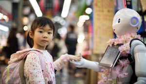 Jeune fille de type asiatique tenant la main d’un robot