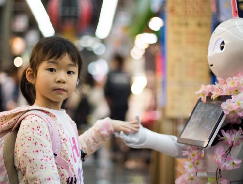 Jeune fille de type asiatique tenant la main d’un robot